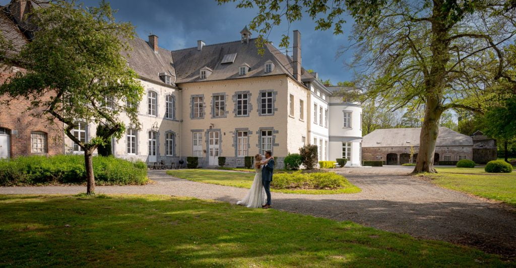Les mariés enlacés dans le parc d'un château au printemps