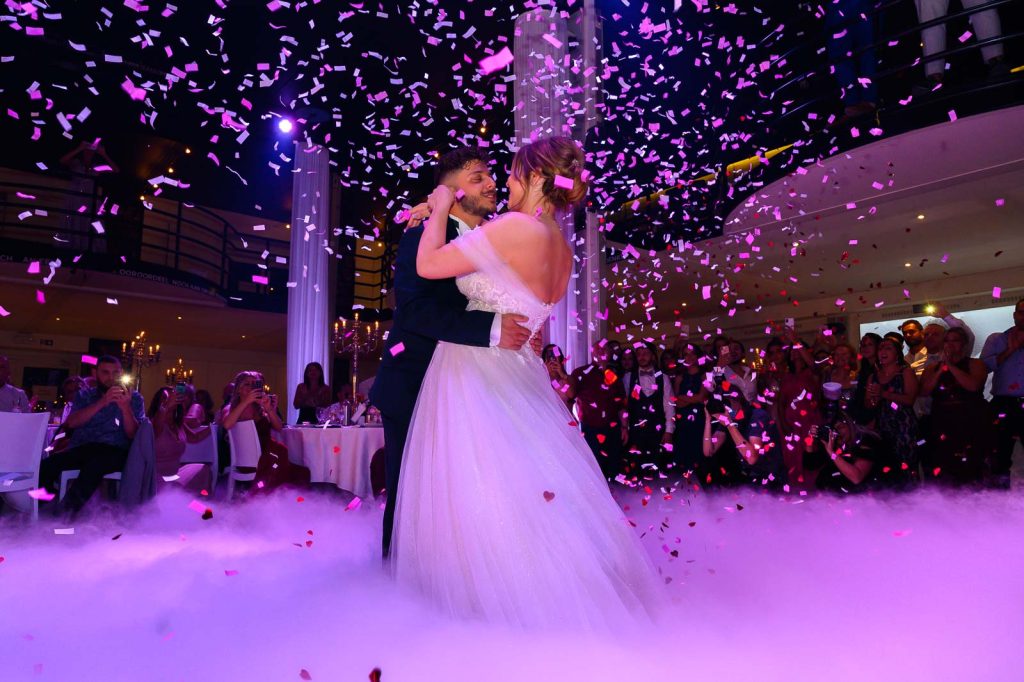 Première danse des mariés sous les confettis et la fumée lourde