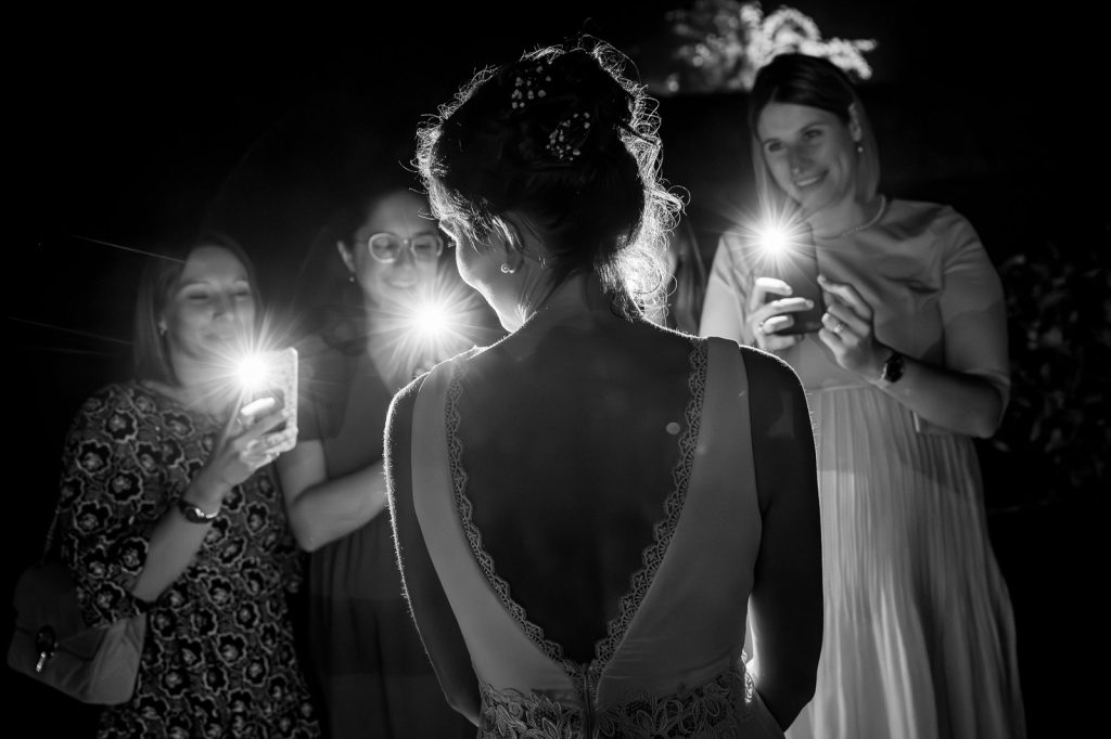 Les amies filment la mariée avec leurs téléphones, en noir et blanc