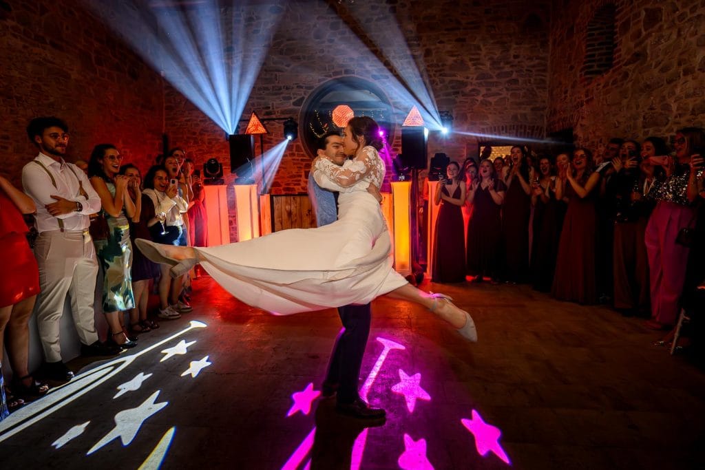 Le marié fait tournoyer la mariée sur la piste de danse, jeux de lumière