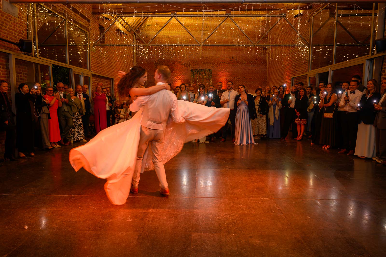 Première danse des mariés en lumière orangée – mariage Ferme-Château du Sart, Ampsin (Amay)